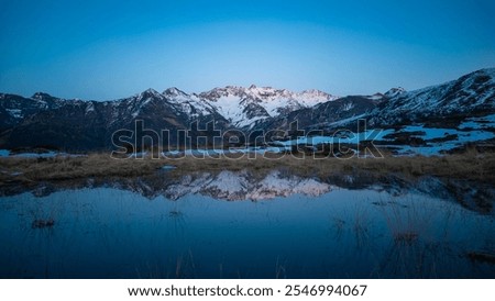 Sunset over the Pyrenees mountains with the reflection of the peaks in the water of the lake High quality 4k footage
