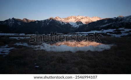 Sunset over the Pyrenees mountains with the reflection of the peaks in the water of the lake High quality 4k footage