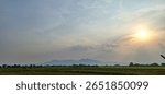 Sunset Over Rice Fields with Mountain Horizon – Peaceful Rural Landscape