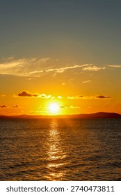 Sunset over a river. Sky with clouds and bluish and orange hues.