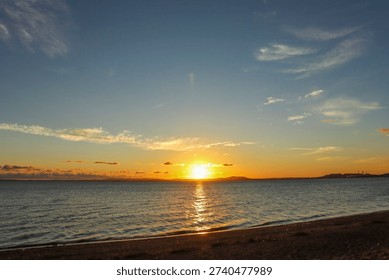 Sunset over a river. Sky with clouds and bluish and orange hues.