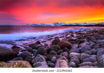 Sunset over a rocky beach. Bolders beach at sunset. Sunset sea beach landscape. Colorful sunset on the boulder beach