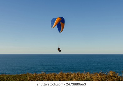 Sunset over the sea in Basque country with people doing paragliding
 - Powered by Shutterstock