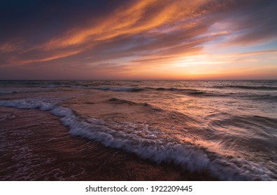 Sunset over the sea shore, sandy beach, colorful sky