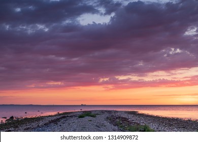 Sunset over a stone beach with dramatic colors and clouds. Hittarps revet in Helsingborg, Sweden is an unknown beauty. 