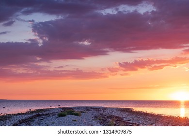 Sunset over a stone beach with dramatic colors and clouds. Hittarps revet in Helsingborg, Sweden is an unknown beauty. 