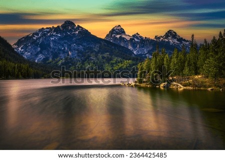 Sunset over Taggart Lake and Grand Teton Mountains in Wyoming, USA. Taggart Lake is a stunning alpine lake in Grand Teton National Park, surrounded by majestic mountains. Long exposure.