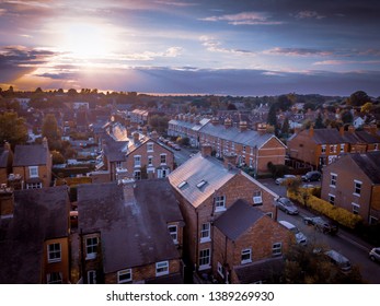 Sunset over traditional British houses with countryside in the background.  A picturesque scene, created by the long shadows and warm glow