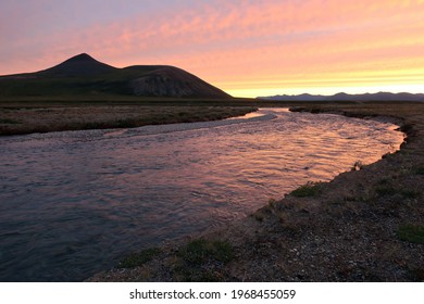 Sunset over tundra river and mountains in Chukotka, Far East Russia