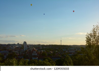 Sunset over Vilnius, Lithuania, where 3 hot-air balloons fly over