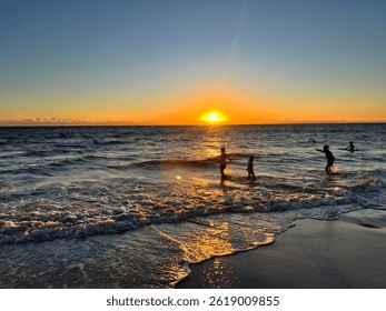 Sunset over Whitfords beach, Perth, Western Australia with children playing.