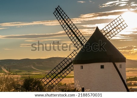 Sunset over the windmill of Consuegra. The land of Don Quixote. Beautiful warm colours on sky and landscape. 
