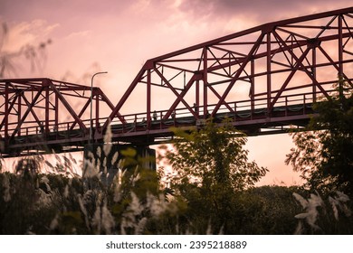 "Sunset paints the sky over Xiluo's iron bridge, casting a warm glow on the sweet-rooted Kochia grass below." - Powered by Shutterstock