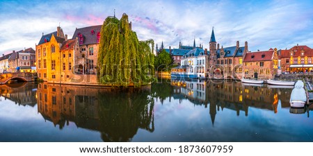 Sunset panorama Brugge city centre, often referred to as The Venice of the North, with famous Rozenhoedkaai illuminated in beautiful twilight, West Flanders province, Belgium