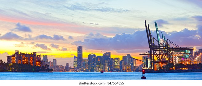 Sunset panorama of Miami Port, Fisher Island and downtown, colorful city light and Biscayne Bay water