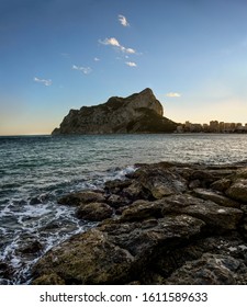 Sunset panorama over Calpe beach with views on Ifach Mountain and sea with rocks