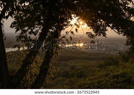 Sunset panorama, sun, tree, forest, city outskirts, river. Soft sunlight. Warm summer evening. Ufa, Bashkiria