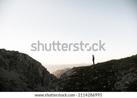 Sunset in Picos de Europa Pico Urriellu with hiker looking into the horizon