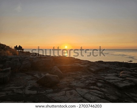 Sunset at Point Prim in Digby, Nova Scotia, overlooking the Bay of Fundy at low tide. Rugged rocky shoreline, golden sky, and peaceful Atlantic Canada coastal scenery.