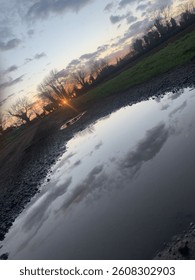 Sunset with puddle reflection of the sky