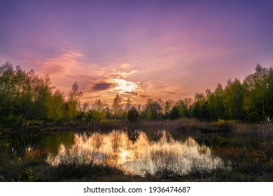 Sunset in purple mood on a lake with reflections on the water