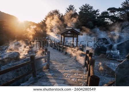sunset rays light through sulfur gas at Hell valley Jigoku of Mount Unzen onsen hot springs by ryokan hotel, Nagasaki, Japan. Famous travel destination for hot spring water and gas by volcanic field.