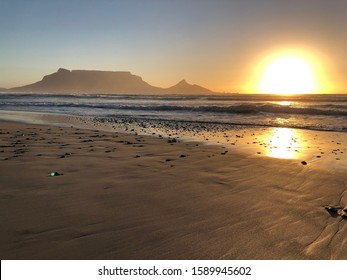 Sunset rays next to Table Mountain and Lionshead from  the beach on Sunsetbeach in Cape Town, South Africa