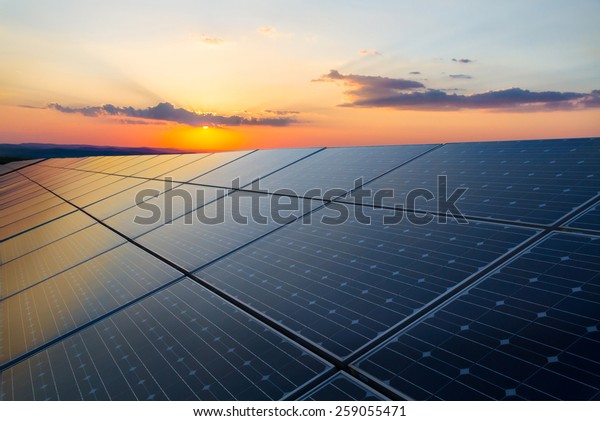 Sunset rays over a\
photovoltaic power plant