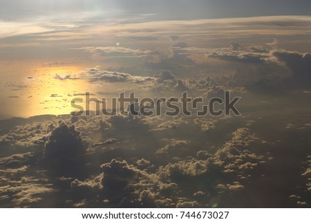 Sunset reflect Dense Fluffy Puffs of White Clouds red sky at high level attitude, view from window airplane so Unsharp and Noise, copy space
