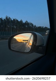 Sunset Reflected in Car Side Mirror While Driving on Highway