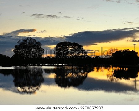 Sunset reflected over lake surface on Parque Sarah Kubitschek in Brasília, Brazil.