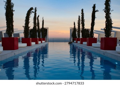 Sunset Reflected in Rooftop Infinity Pool hotel resort orange blue sky water swimming red reflection mirror image photo photograph editorial luxury trees plants symmetrical landscape png travel clouds hotel