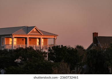 The sunset reflected in the windows of a vacation rental on pawleys island - Powered by Shutterstock