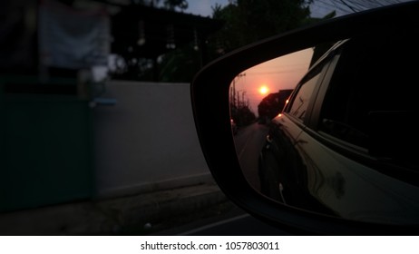 Sunset reflection in the mirror of car.