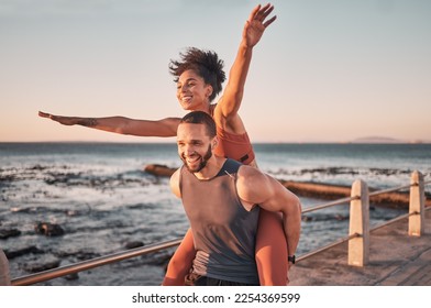 Sunset, relax and couple piggyback by ocean enjoying holiday, vacation and quality time on weekend. Love, freedom and happy black man and woman after exercise, fitness workout and training by sea - Powered by Shutterstock