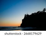 Sunset at Ruby Beach, Olympic National Park, Washington State. Colorful sky reflecting on wet sand with sea stacks and gentle ocean waves.