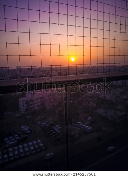 sunset scene from office balcony railing grid grill jail\
glass cars  aerial from top view road busy life relax luxury travel\
colorful 