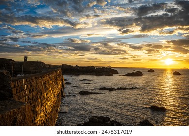 Sunset in Scotland, Dunbar Harbor, rocky cliffs, horizon over water of the North Sea, colorful sky - Powered by Shutterstock