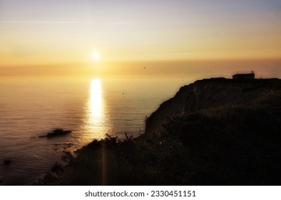 sunset at sea,  photo made with a diffusing filter to give it a feeling of fantasy and mystery, Promotional photography of the landscape of Asturias, Spain, around the Cape Vidio lighthouse