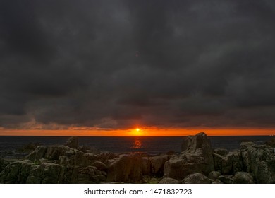 The sunset at seaside.  It's between clouds and sea. 