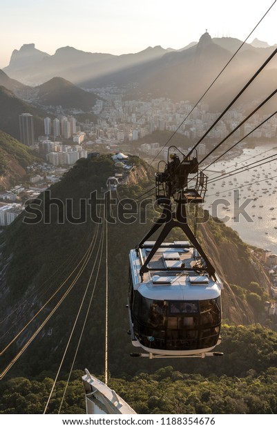 Sunset seen from the Sugar Loaf Mountain with\
beautiful landscape of the cable car, the city and mountains, Rio\
de Janeiro, Brazil