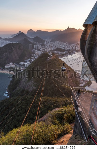 Sunset seen from the Sugar Loaf Mountain with\
beautiful landscape of the cable car, the city and mountains, Rio\
de Janeiro, Brazil