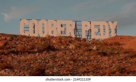 sunset shot of a large sign with the words coober pedy on a hill at coober pedy in outback south australia