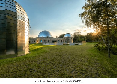 Sunset at the Silesian Planetarium. Reflecting the sky and sunbeams of the planetarium and observatory domes. Aluminum panels on the roof. Chorzow, Silesian Park, Poland