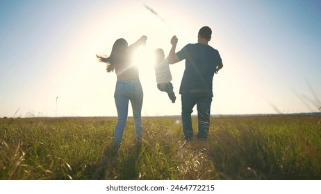 Sunset silhouette of family is running. happy family kid dream concept. The family run the park together. parents and kid are running across a field in the park at sunset holding hands lifestyle - Powered by Shutterstock