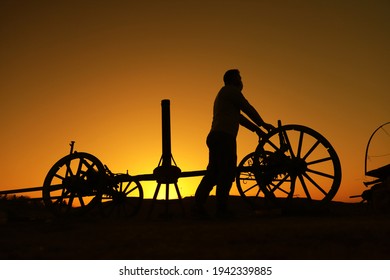 Sunset And Silhouette Of Horse Carriage Mechanic.