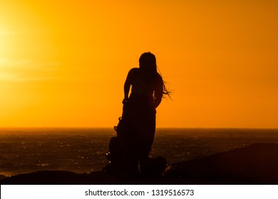 Sunset Silhouette: Same Sex Couple Of Girls At Sunset In Camps Bay Tidal Pool, Cape Town, South Africa