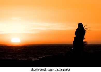 Sunset Silhouette: Same Sex Couple Of Girls At Sunset In Camps Bay Tidal Pool, Cape Town, South Africa