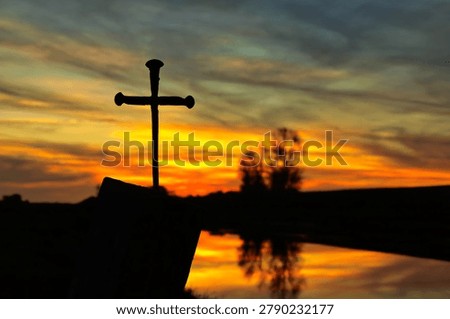 Sunset sky behind a cross made of nails