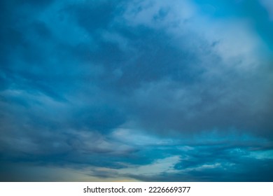 Sunset sky in bright blue tones. A wide panorama of the evening sky covered with dark clouds. Background with impending bad weather in anticipation of rain. - Shutterstock ID 2226669377